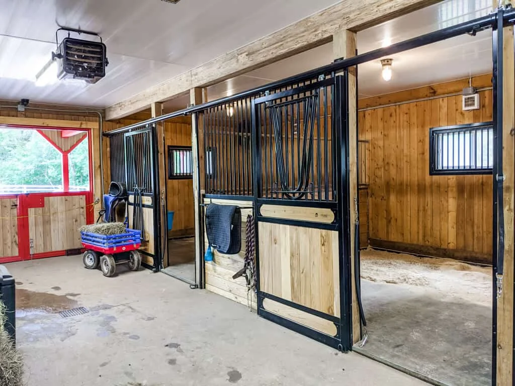 a horse barn with a horse stall and a horse trailer