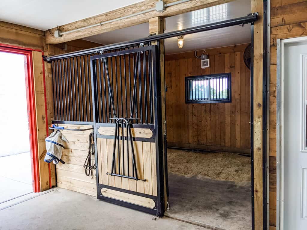 A Horse Stall With A Door And A Horse