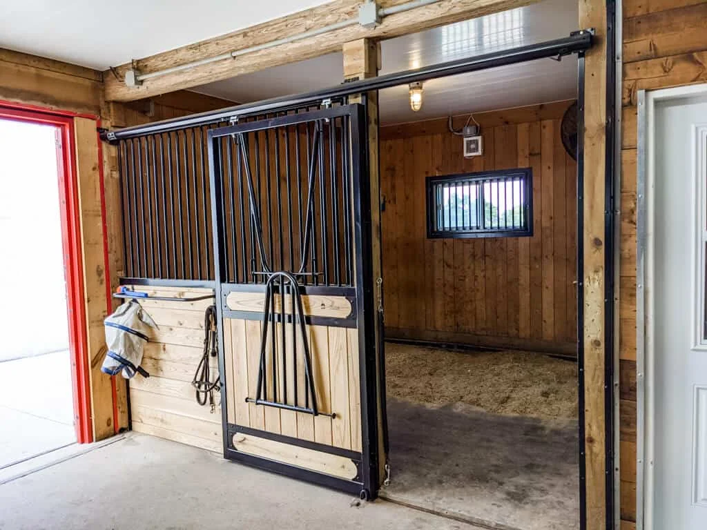 a horse stall with a door and a horse